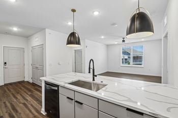 Modern kitchen island with pendant lighting and marble countertop